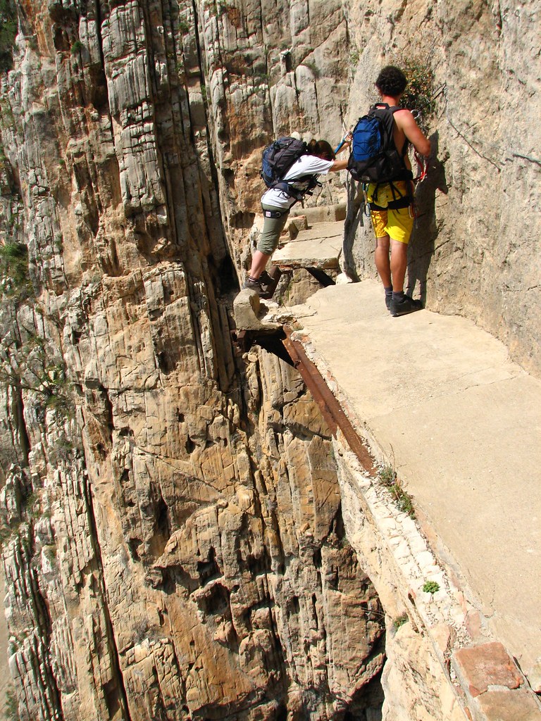 Excursionistas pasando por una pasarela a punto de caerse en el Caminito del Rey