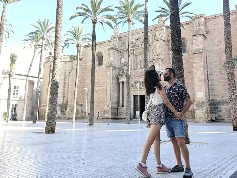 Raissa e Jesús diante da Catedral de Almería, explorando os pontos de interesse em Almeria.