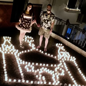 Casal entre velas que formam o desenho de um palácio árabe no Festival Luna Mora de Guaro